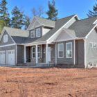 grey cape cod house with two car garage