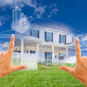 A blueprint of a house overlaid on a space of land with fingers outlining it.